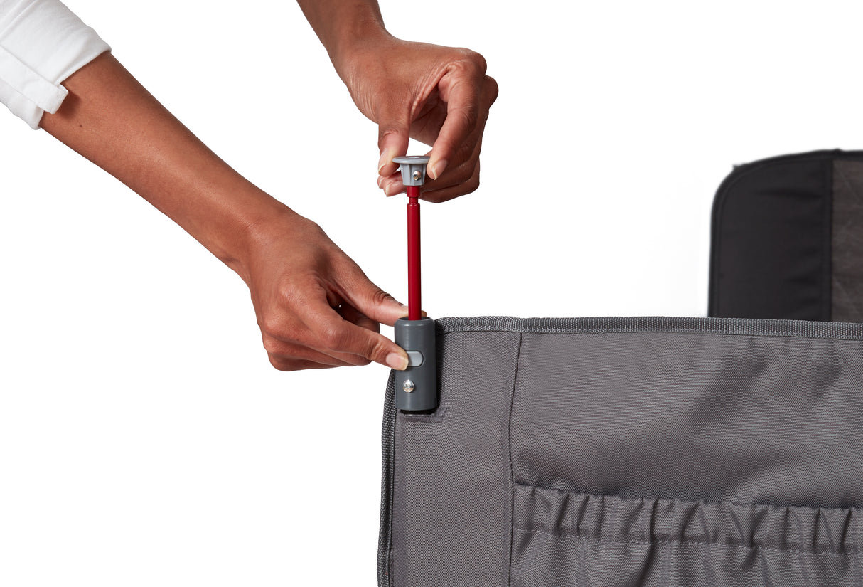 Person adjusting the canopy pole on the gray folding wagon with a white background