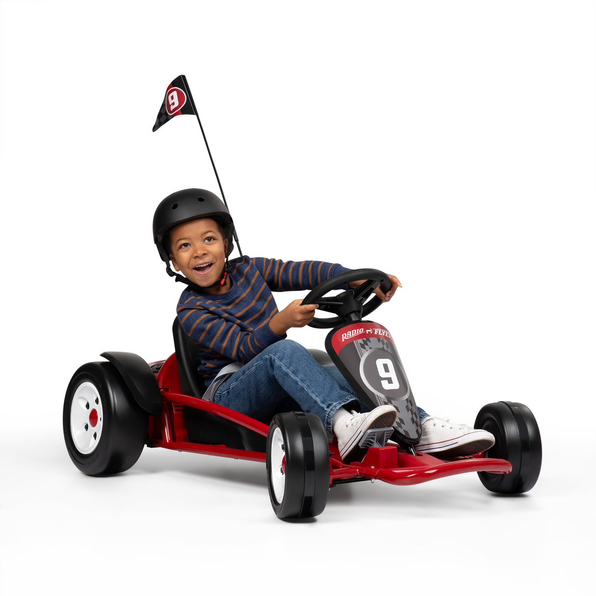 Child driving a red go kart with a helmet on a white background