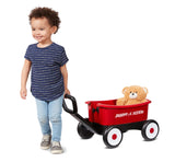 child pulling wagon with teddy bear inside
