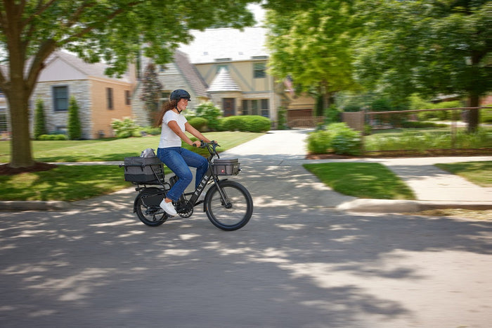 woman biking on a suburban sidewalk 