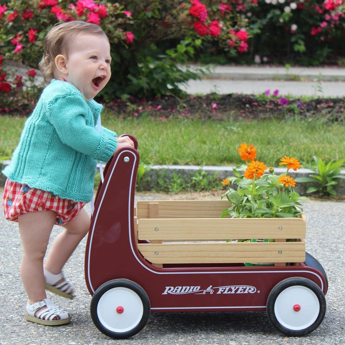 child pushing a toy walker wagon