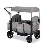 Gray two kid stroller wagon with a canopy and rear storage bag on a white background