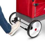 A close-up of the back of a red wagon with a woman's foot pressing down on the rear foot brake