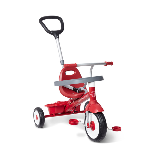 A red tricycle with a push handle on a clean white background.