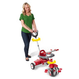 Woman turning the push handle of a red tricycle showing how the push handle steers the trike