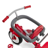 A red and gray children's tricycle with a child safety bar, red handlebar grips, and a gray safety harness, shown on a white background.