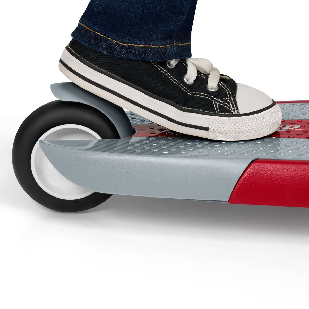 Close-up of a child's foot pressing down on the rear foot brake