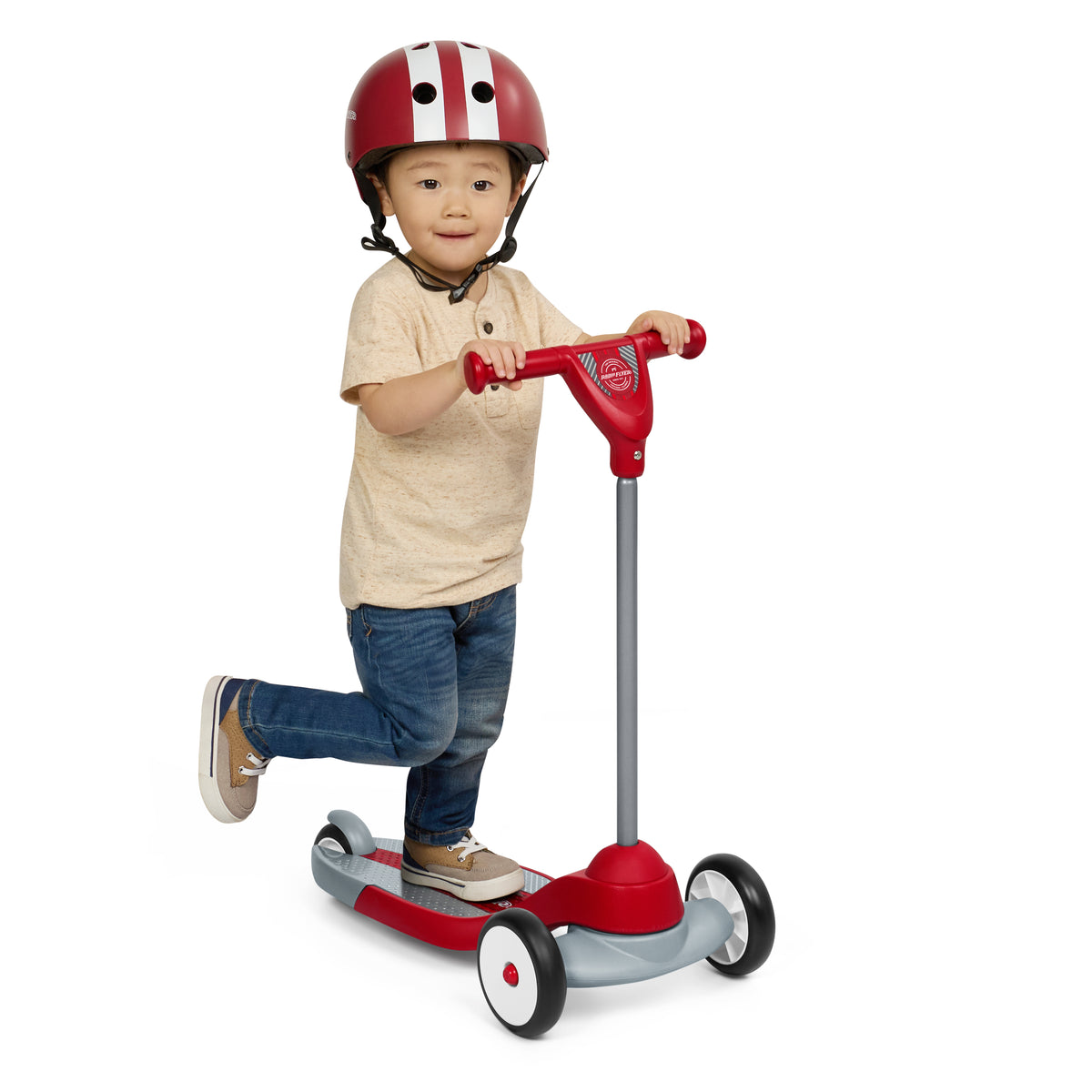 Toddler boy wearing a red helmet riding the red three wheeled scooter