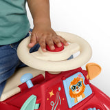 A child's hand honking the red horn on the cream steering wheel of the red Radio Flyer ride-on push car