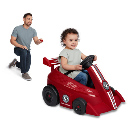 Young child independently driving the Grow With Me Racer using the steering wheel and push-button controls