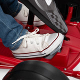 Child foot pressing on the gas pedal of the red go kart