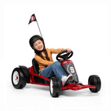 Child driving a red go-kart with a helmet on a white background