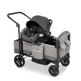 Gray stroller wagon with a car seat resting on the car seat adapter on the side walls of the wagon