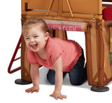 Girl crawling through secret play space underneath the platform